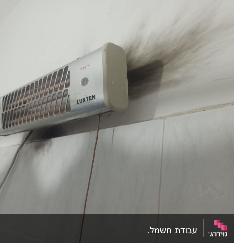 תנור חימום חשמלי עם סימני פיח על הקיר
